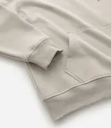 Saco con capucha color beige, con cordón ajustable, bolsillo canguro, mangas largas y barras ajustadas. Confeccionado en algodón con felpa, de corte comfort.