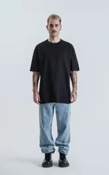 Remerón negro de corte extra oversize con hombros caídos y cuello redondo.