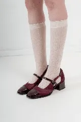 Zapato tipo ballerina color borgoña, con puntera charolada, hebilla lateral y taco cuadrado.