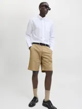 Bermuda chino color beige confeccionada en algodón, con bolsillos delanteros y traseros, y cierre con cremallera.