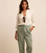 Pantalón cargo color verde claro, con cintura elástica ajustable con cordón, bolsillos laterales tipo cargo y corte holgado.