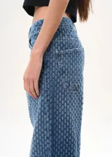 Pantalón de jean azul con textura en relieve, corte wide leg y tiro medio.