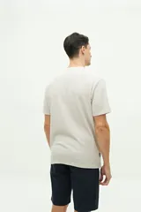 Remera color beige con textura, de manga corta, corte regular y logo estampado en el pecho.