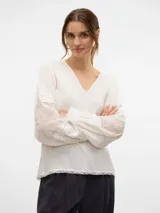 Camisa blanca de mangas largas abullonadas con detalle de bordado en las mangas y escote en V.