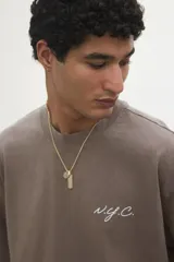 Remera color marrón con efecto lavado, cuello redondo y manga corta. Estampa pequeña con la inscripción 'NYC' en color blanco.