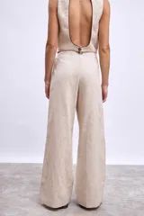 Pantalón ancho de tiro alto color azul marino, con pliegues frontales y ribetes en color naranja quemado en los bordes del bolsillo y la cintura.