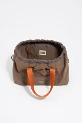 Mini bolso de nylon color marrón con asas de mano naranjas y cordones ajustables verdes. Incluye logo metálico de Bimba y Lola y bolsillo interior.