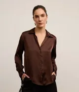 Camisa marrón de satén con cuello inglés, manga larga, recortes y cierre frontal con botones.