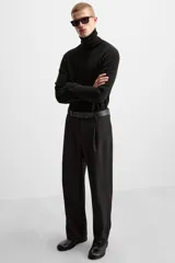 Pantalón negro de corte recto con cinturón de cuero sintético, pliegues frontales, bolsillos laterales y traseros con solapa.