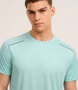 Remera deportiva gris con cuello redondo, mangas cortas, estampa heat print y detalle en los hombros. Confeccionada en tejido de malla con tecnología Dry.