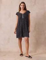 Camisón corto negro con estampado de lunares blancos, escote en V con puntilla blanca y botones.