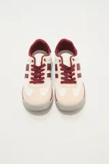 Zapatillas bajas color beige y blanco con detalles en verde agua.