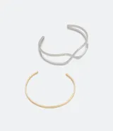 Set de dos pulseras rígidas de metal: una dorada lisa y otra plateada doble con diseño entrelazado.