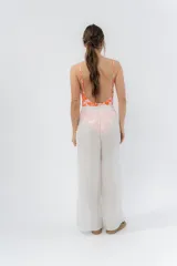 Pantalón blanco de gasa liviana con cintura elástica y aberturas laterales con detalle de pompones.