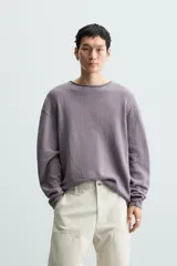 Jersey color crudo de algodón con textura, corte relaxed fit, cuello redondo y manga larga. Acabados en rib con detalle de vuelta.