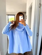 Sweater celeste de tejido de punto, con cuello alto y mangas largas.