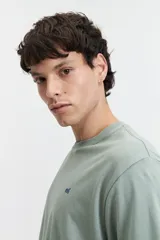 Remera color salmón de corte clásico, cuello redondo y logo bordado en el pecho.