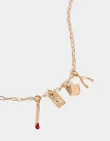 Collar dorado con cadena de eslabones y dijes colgantes: fósforo con cabeza roja, naipe con corazón y dado esmaltado rosa.