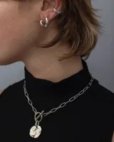 Collar plateado con cadena de eslabones y dije circular texturizado.