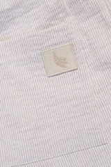 Pantalón largo a rayas verticales celestes y blancas, confeccionado en tejido de algodón. Con cintura elastizada y cordón de algodón para regular el calce. Incluye bolsillos laterales y trasero.