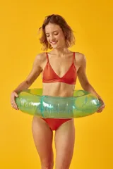 Conjunto de bikini blanco con textura, compuesto por un corpiño de triángulo fijo con breteles regulables y almohadillas desmontables, y una bombacha vedetina con frunce elástico en los costados.