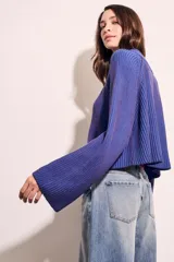 Sweater azul de tejido de punto acanalado, con cuello polo y cierre frontal parcial.