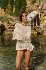 Sweater tejido color crudo, de manga larga y escote redondo. Tejido calado con caída relajada.