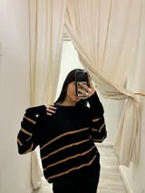 Sweater de tejido Bremer negro con rayas horizontales color tostado, de corte holgado y cuello redondo.
