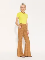 Pantalón flare color camel de broderie con aberturas en botamangas cerradas con broches dorados. Presenta bolsillos delanteros diagonales con vivos en cuero al tono.