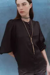 Camisa negra de lino con cuello mao, mangas abullonadas con elástico en los puños y botones forrados en la misma tela.