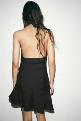 Vestido corto marrón con cuello halter que se ata al cuello, detalle de frunces en la falda y volados asimétricos en el ruedo.