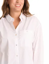Camisa oversize blanca de tencel, con cuello con solapa, botones frontales, mangas largas con hombros caídos y puños anchos. Incluye un bolsillo en la parte delantera y un tablón central en la espalda. El bajo es redondeado y asimétrico, más largo en la espalda.