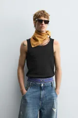 Musculosa blanca de algodón con cuello redondo y sisas amplias, corte ajustado.