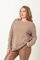 Buzo de punto arroz color beige, con cuello redondo y detalles en los costados.