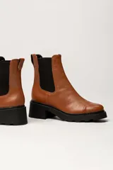 Bota Chelsea de cuero color marrón con elástico lateral negro, suela track y taco cuadrado.