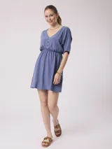 Vestido corto azul con escote en V, mangas cortas y cintura elastizada. Cierre frontal con botones.