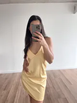 Vestido corto amarillo de satén con breteles finos y escote en V.