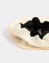 Maxi scrunchie con volados de tela plisada color crema y centro de tela lisa color negro.