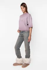 Remera de jersey color lila con efecto desgastado, corte Boxy fit, cuello alto en Rib al tono y manga corta. Estampa láser en el delantero.