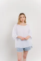 Blusa color beige confeccionada en lino, de corte holgado, mangas 3/4 y cuello redondo.