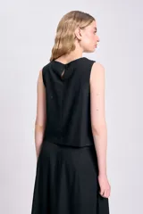 Top negro sin mangas de lino con botones decorativos en los laterales.