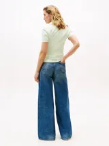 Chomba de piqué de algodón orgánico elástico color verde claro, de corte slim, con cuello clásico, cartera de cuatro botones y logo de Tommy Hilfiger bordado en el pecho.