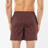 Short de baño marrón con estampado geométrico en blanco y negro, cintura elástica y cordón ajustable blanco.