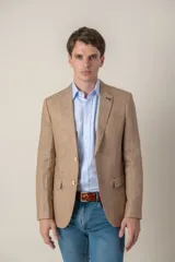 Saco de lino color beige, corte slim fit, con solapa de muesca, cierre de dos botones, bolsillo en el pecho y dos bolsillos delanteros con solapa. Medio forro.