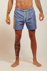 Bañador de hombre color rosa pálido con estampado de golondrinas oscuras. Presenta cintura elástica con cordón ajustable de color crudo y terminales turquesa.