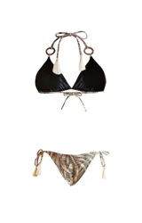 Bikini de dos piezas con estampado de hojas en tonos beige y marrón. El corpiño es de triángulo con tirantes que se atan al cuello y a la espalda, con detalle de argollas de madera en los tirantes y borlas en los extremos. La bombacha es reversible y se ata a los costados con tirantes con borlas.