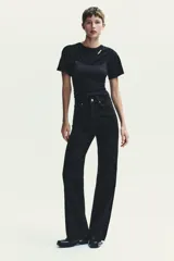 Pantalón de jean azul oscuro, de tiro alto, corte wide leg y largo hasta el tobillo.