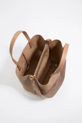 Bolso tote negro de cuero vacuno con doble asa corta y correa de tela extraíble. Interior con tres compartimentos y bolsillo con cremallera. Logo metálico de la marca en el frente.