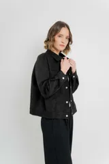 Chaqueta color camel, corte camisa de gamuza con elastano, corte recto abotonado en el frente con botones metálicos y bolsillos grandes en el frente.