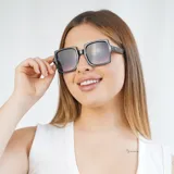 Lentes de sol negros con marco cuadrado y lentes degradadas de negro a violeta.